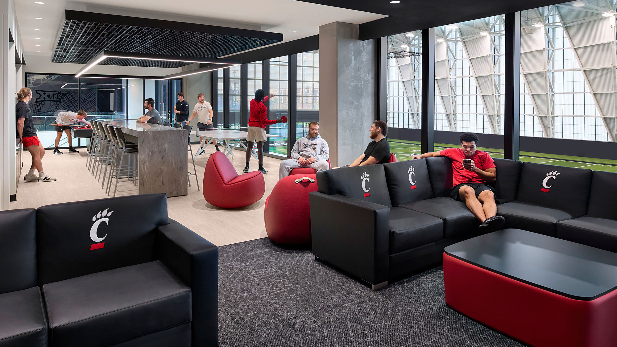 A group of people sitting on a couch in a room with windows.