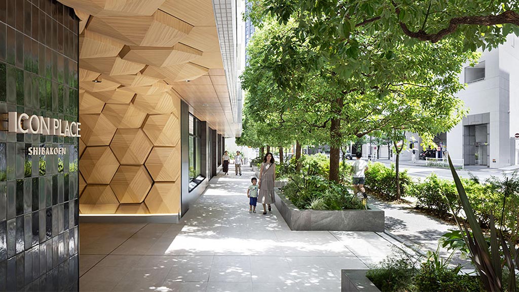 A person and a child walking down a sidewalk between buildings.