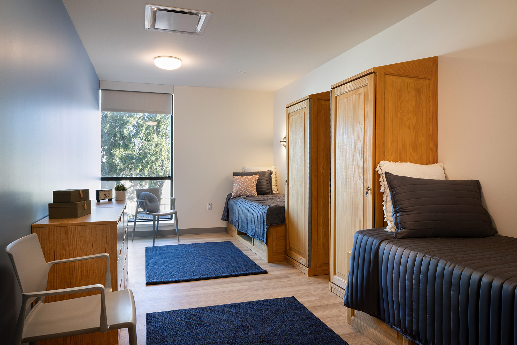 A bedroom with a bed and desk.