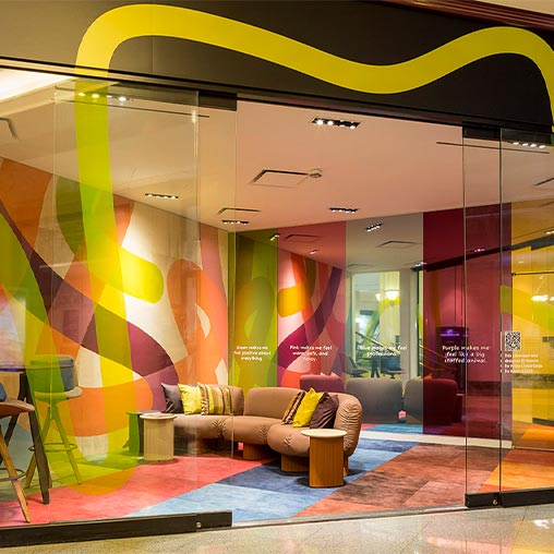 A room with a couch and a window with colorful lights.