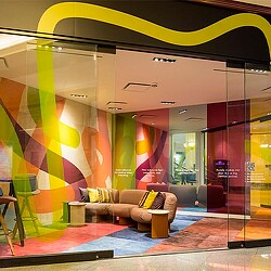 A room with a couch and a window with colorful lights.