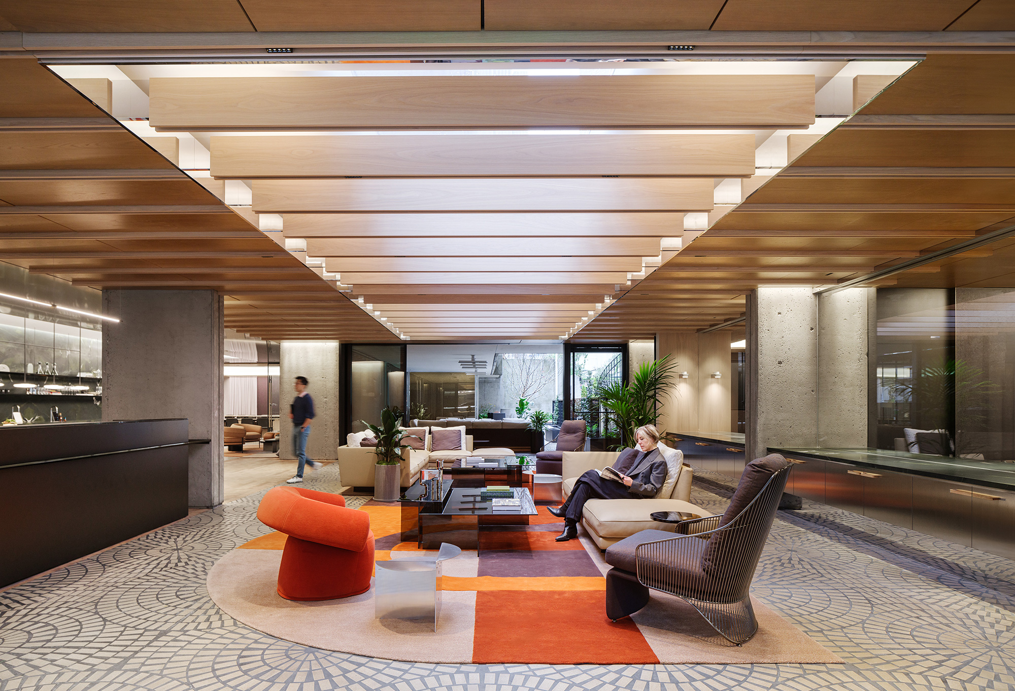 A room with a few people and a large glass wall.