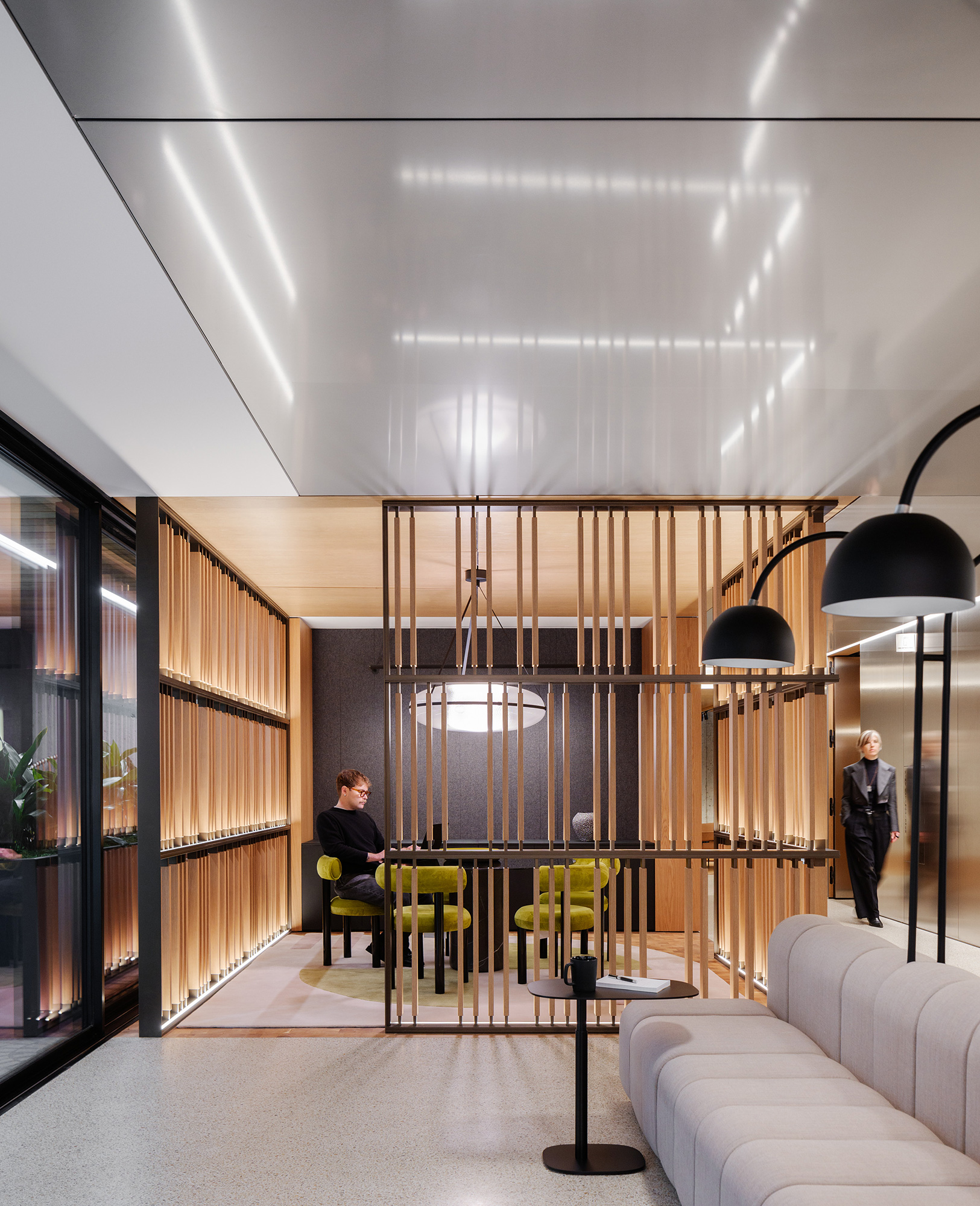 A person sitting in a chair in a room with a large glass wall.
