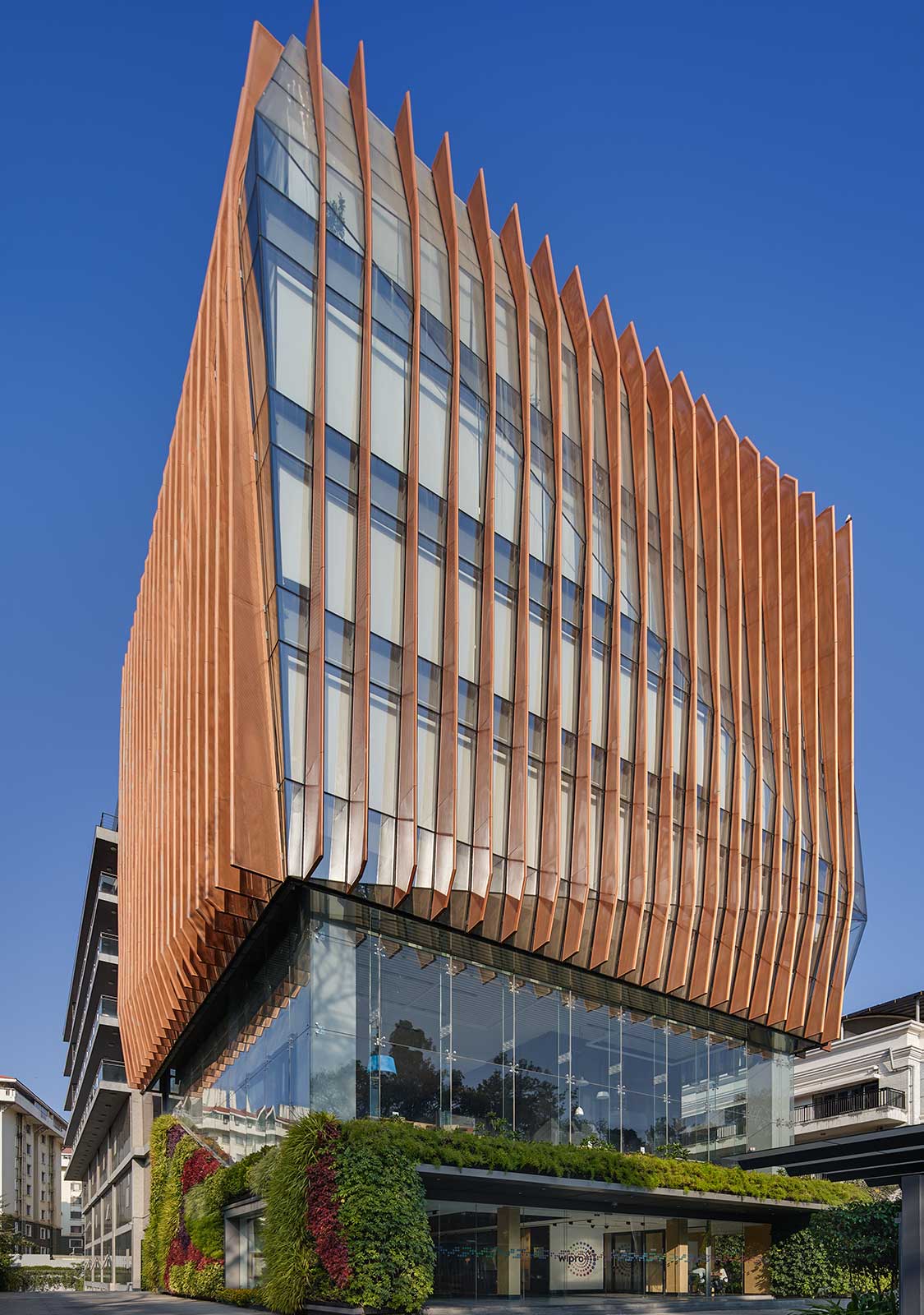 A tall building with many windows with Jean-Marie Tjibaou Cultural Centre in the background.