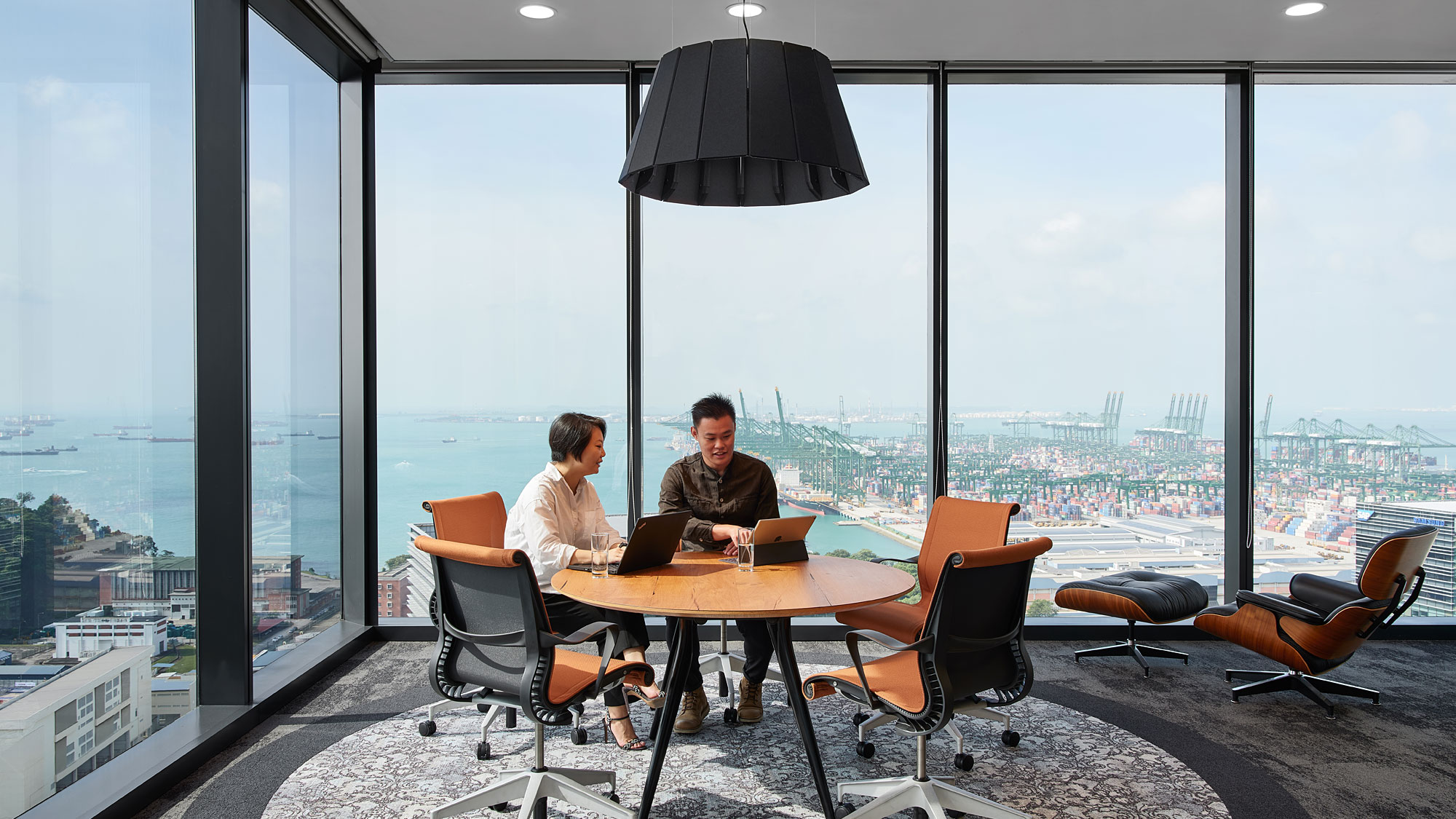 A couple of men sitting at a table with a laptop.