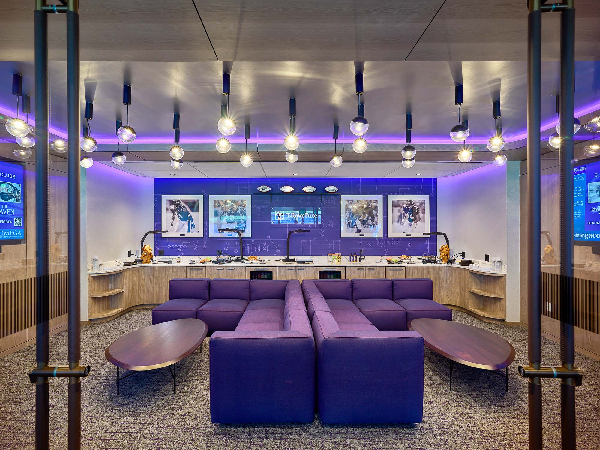 A room with purple couches and a wall of pictures.