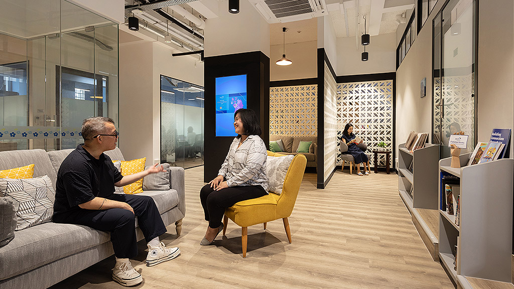 A man and a woman sitting on a couch in a room.