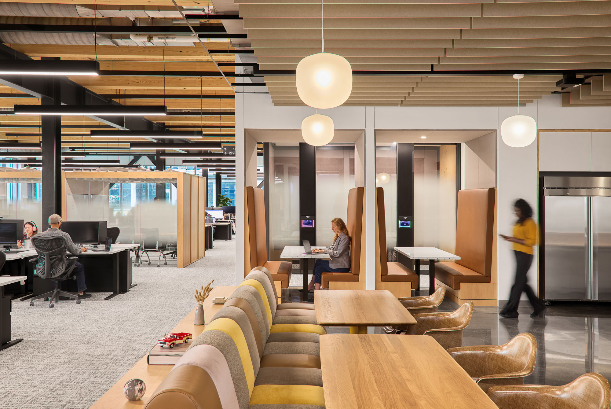 A room with a few people and a few tables and chairs.