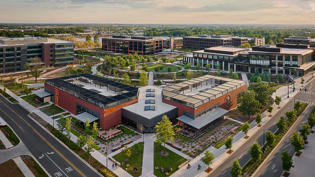 A large building with a courtyard and trees in front of it.