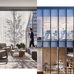 A person standing in a room with windows and a table with chairs.