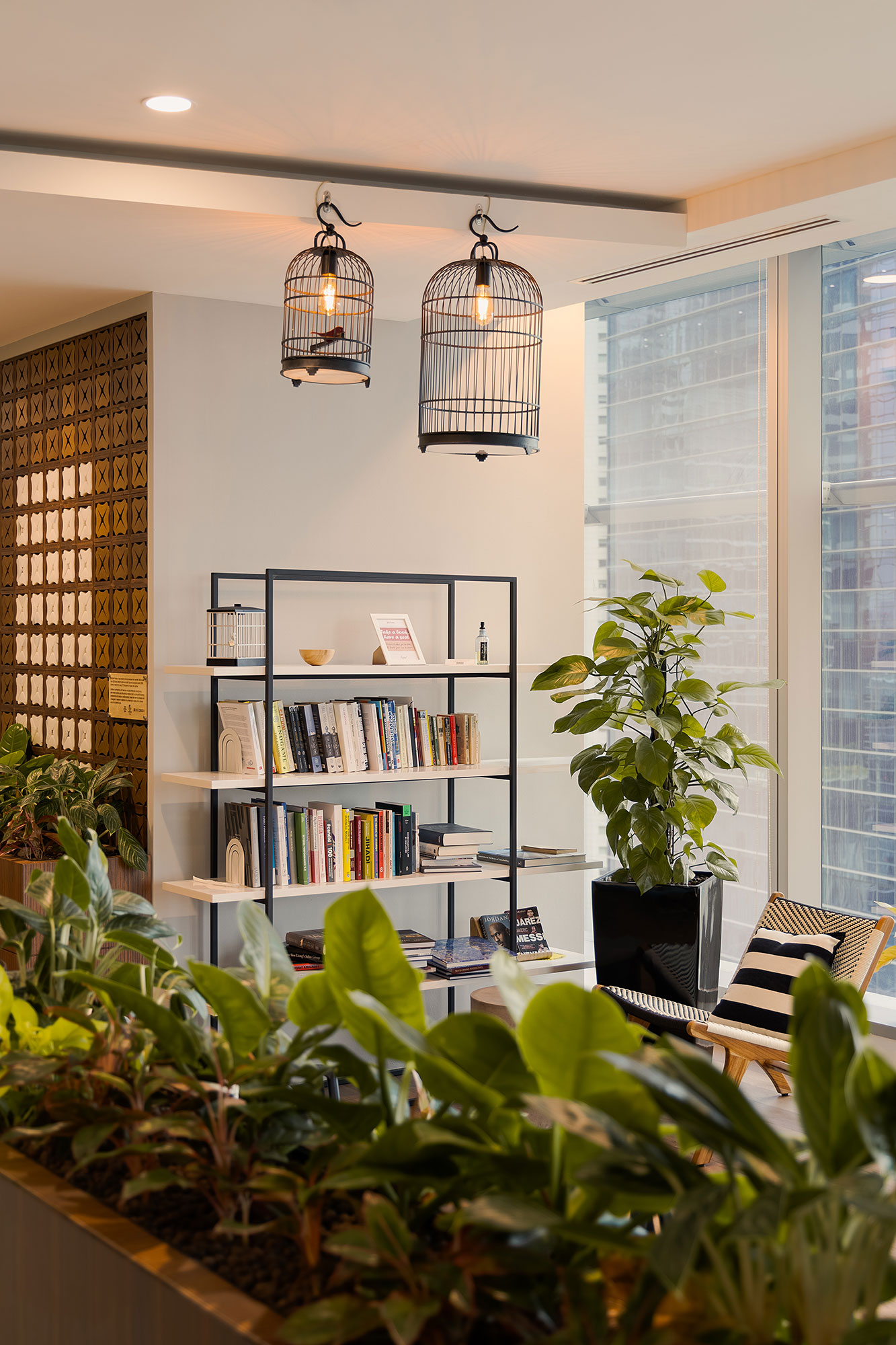 A room with a bookcase and plants.