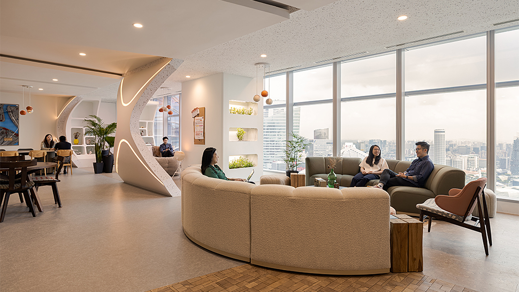 A group of people sitting on a couch in a large room.