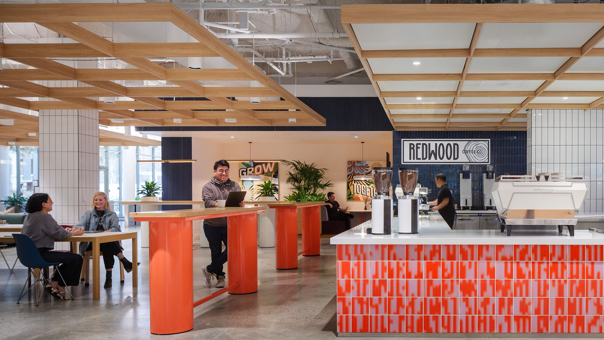 A group of people sitting at a table in a room with a large window.