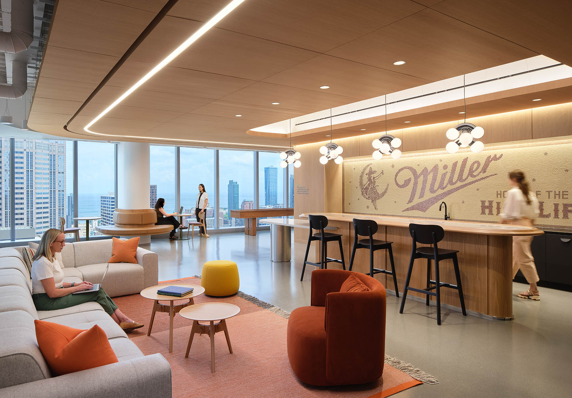 A room with a table chairs and a person standing in it.