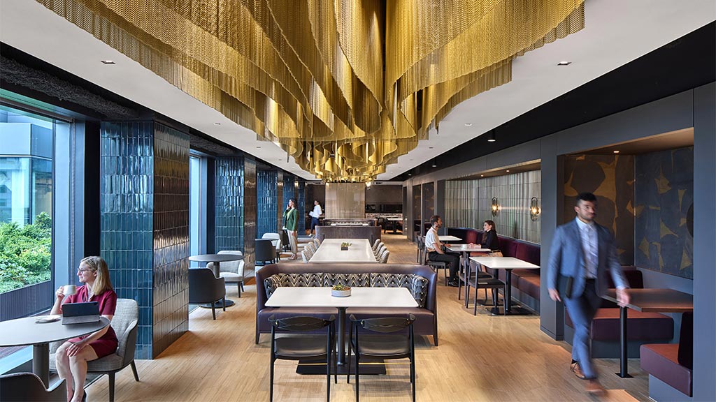 A person walking in a room with tables and chairs.