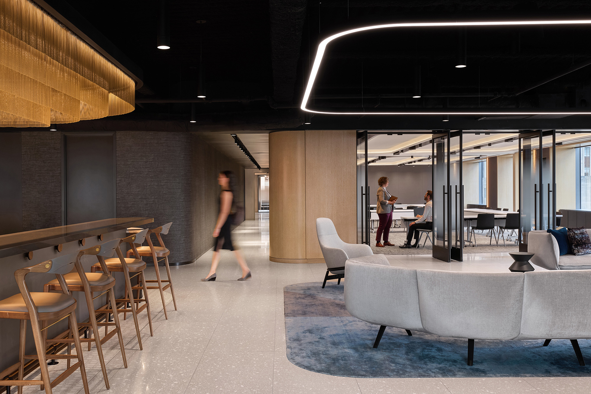 A group of people in a room with tables and chairs.