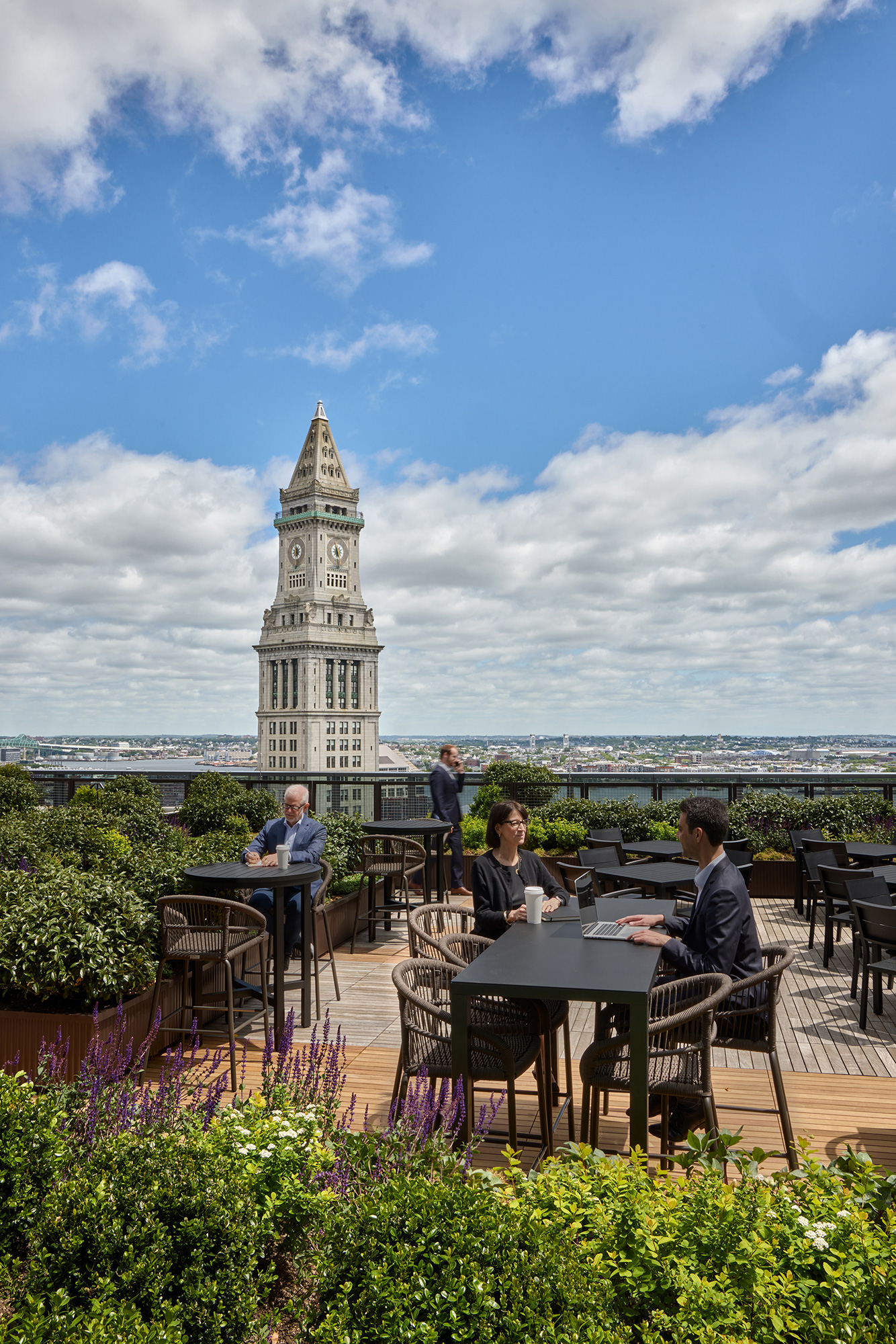 A group of people sitting at a table in front of a tall building.
