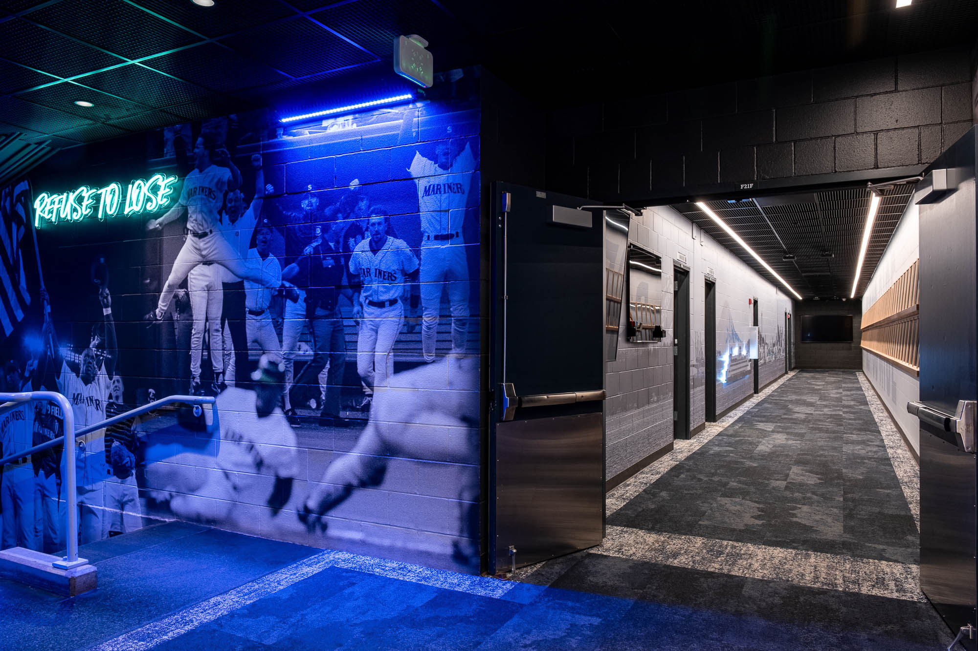 A group of people in white outfits dancing in a room with neon signs.