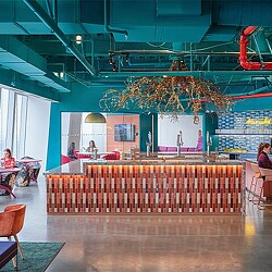 A room with a large table and chairs and a large chandelier.