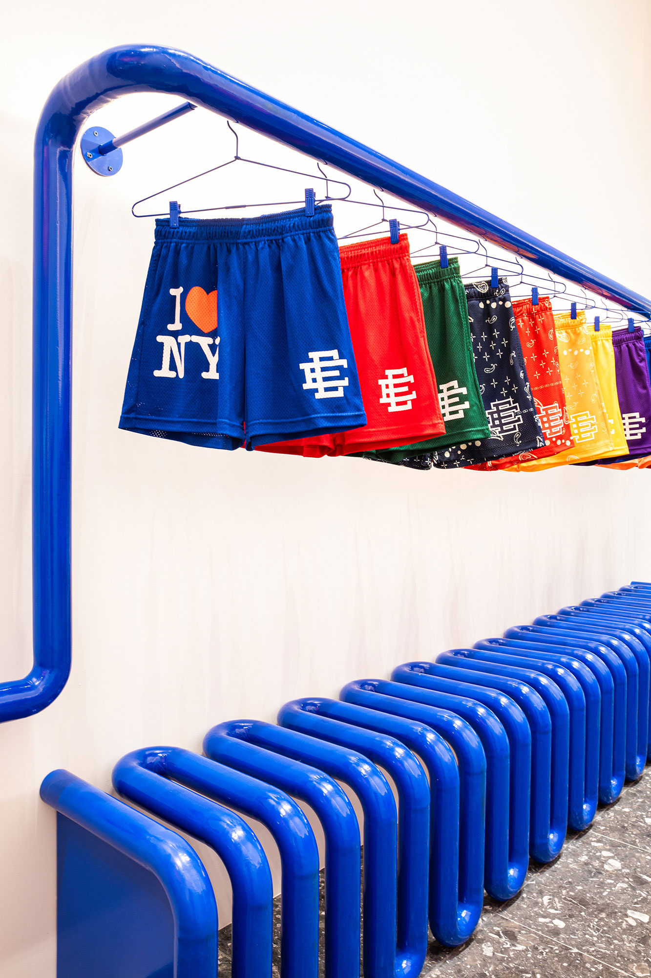 A blue shopping cart with a blue basket and a red and white bag.