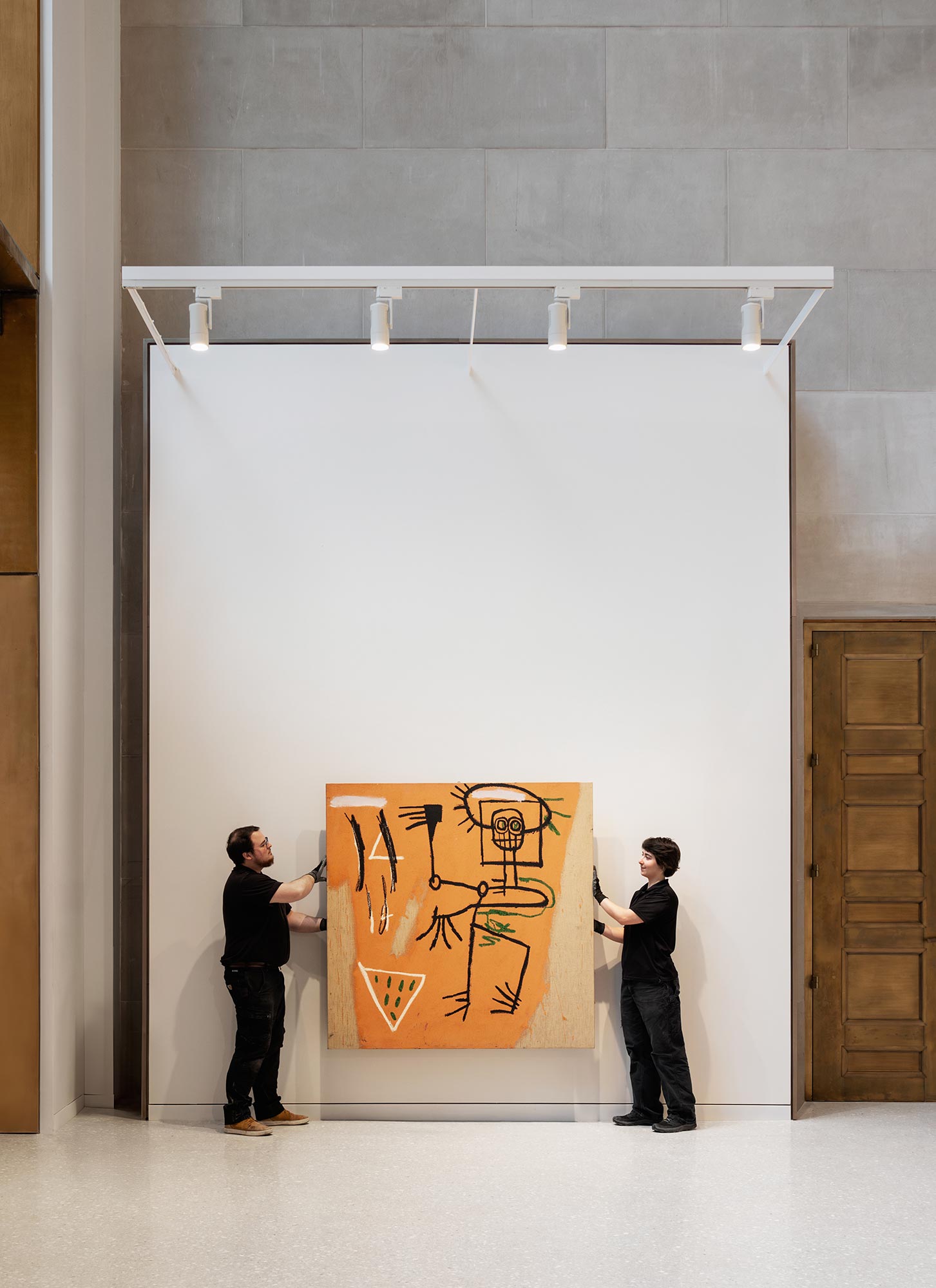 A couple of men looking at a large piece of art.