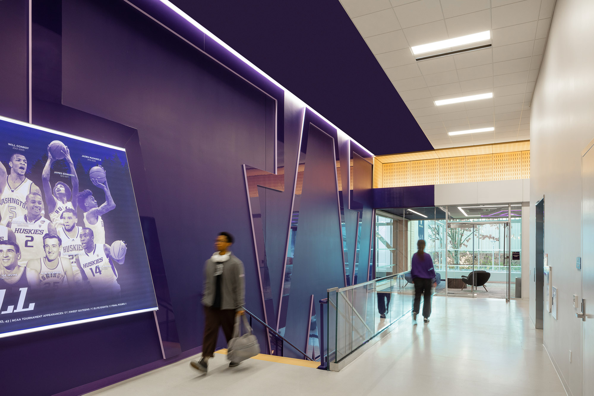 A few people walking in a building.