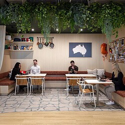 A group of people sitting in a room with a table and chairs.