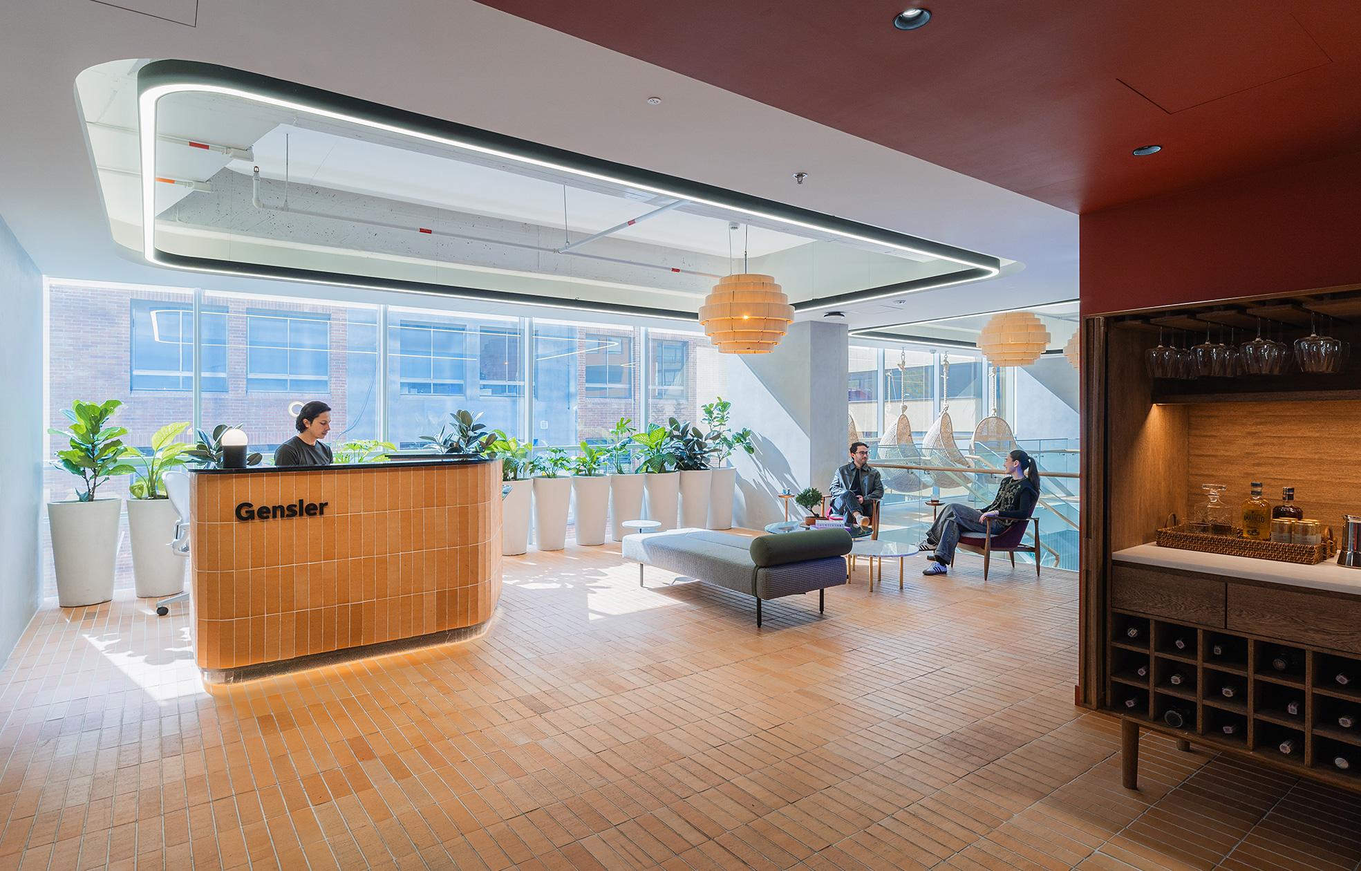 A room with a bar and a couple of people sitting in chairs.