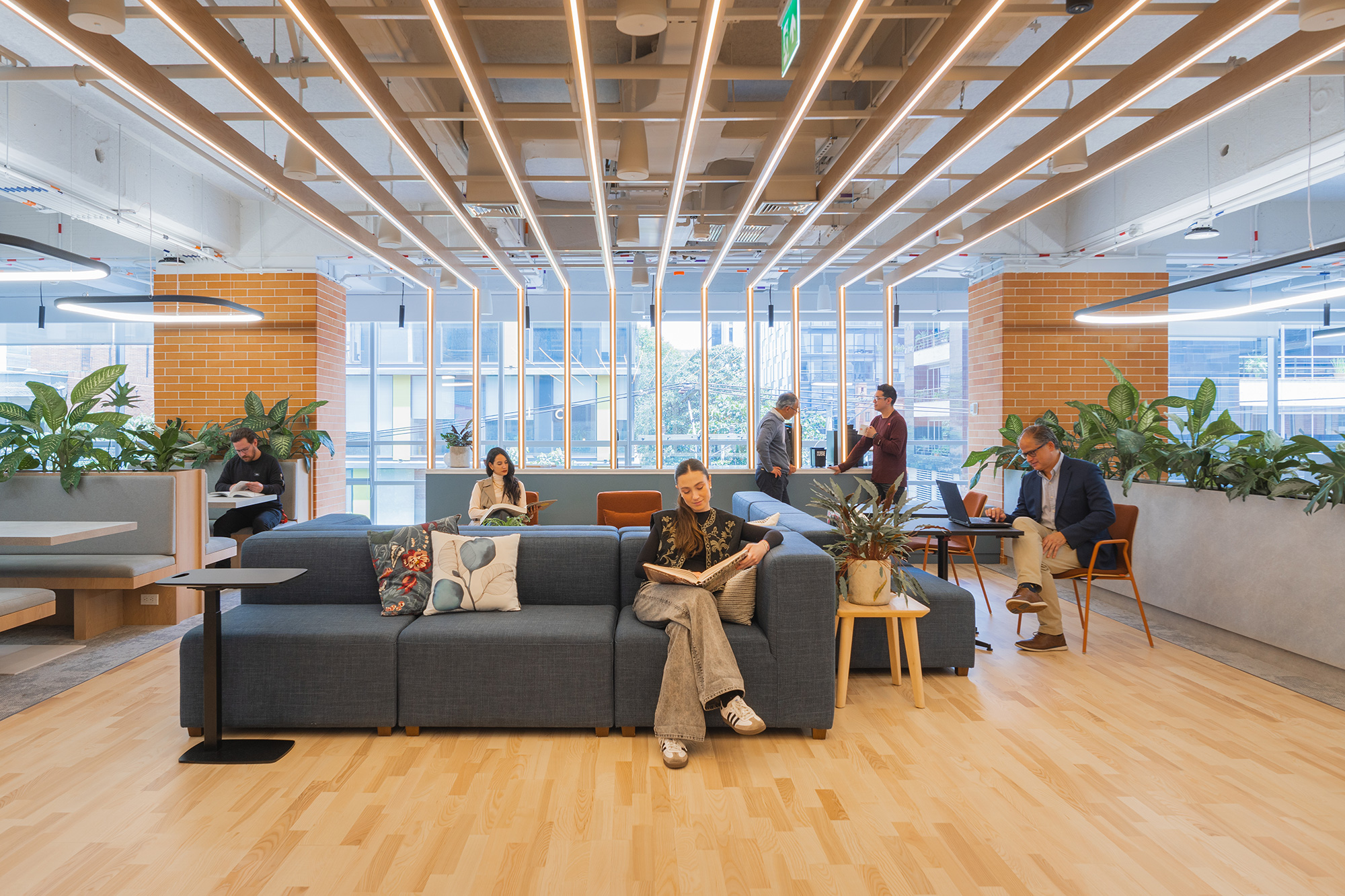 A group of people sitting in a room with a large glass ceiling.