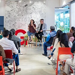 A man and woman talking to a group of people.