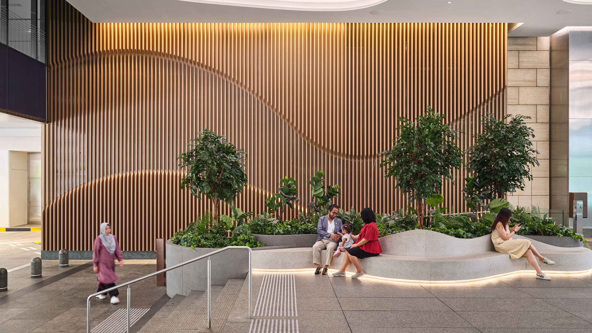 A group of people sitting on a bench outside a building.
