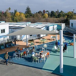 A group of people sitting outside a building.