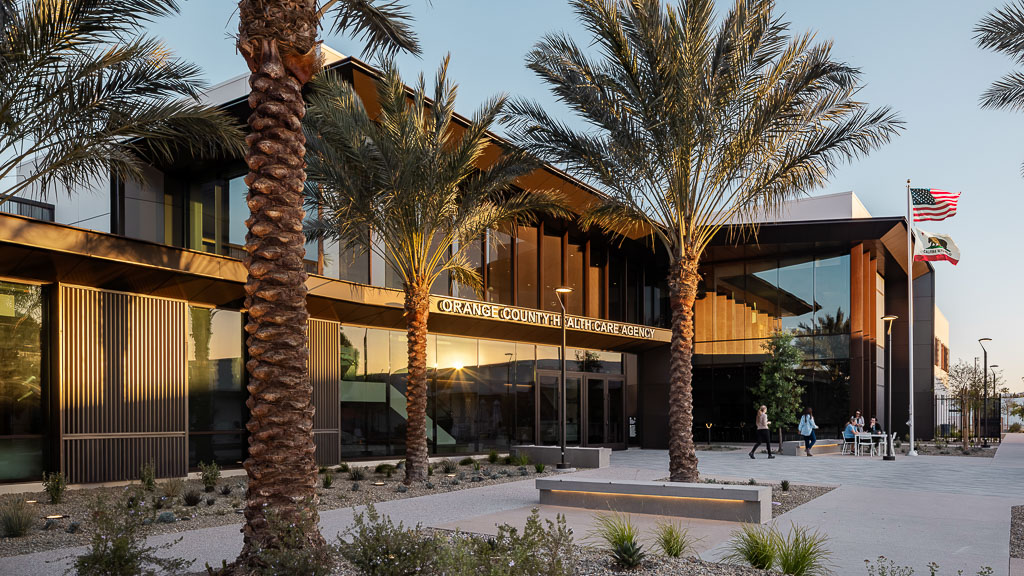 A building with palm trees and a flag on the roof.