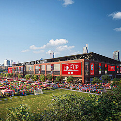 A stadium with a field in front of it.