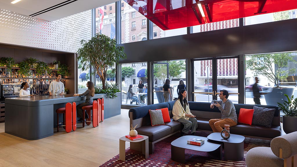A group of people sitting in a room with a large glass wall.