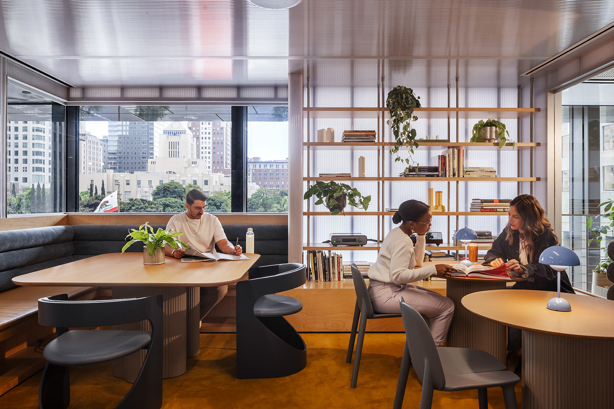 A man and a woman sitting at a table in a room with windows.