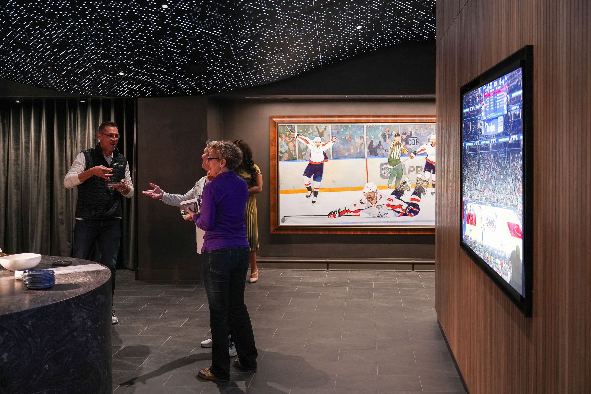 A woman and a man standing in front of a screen.