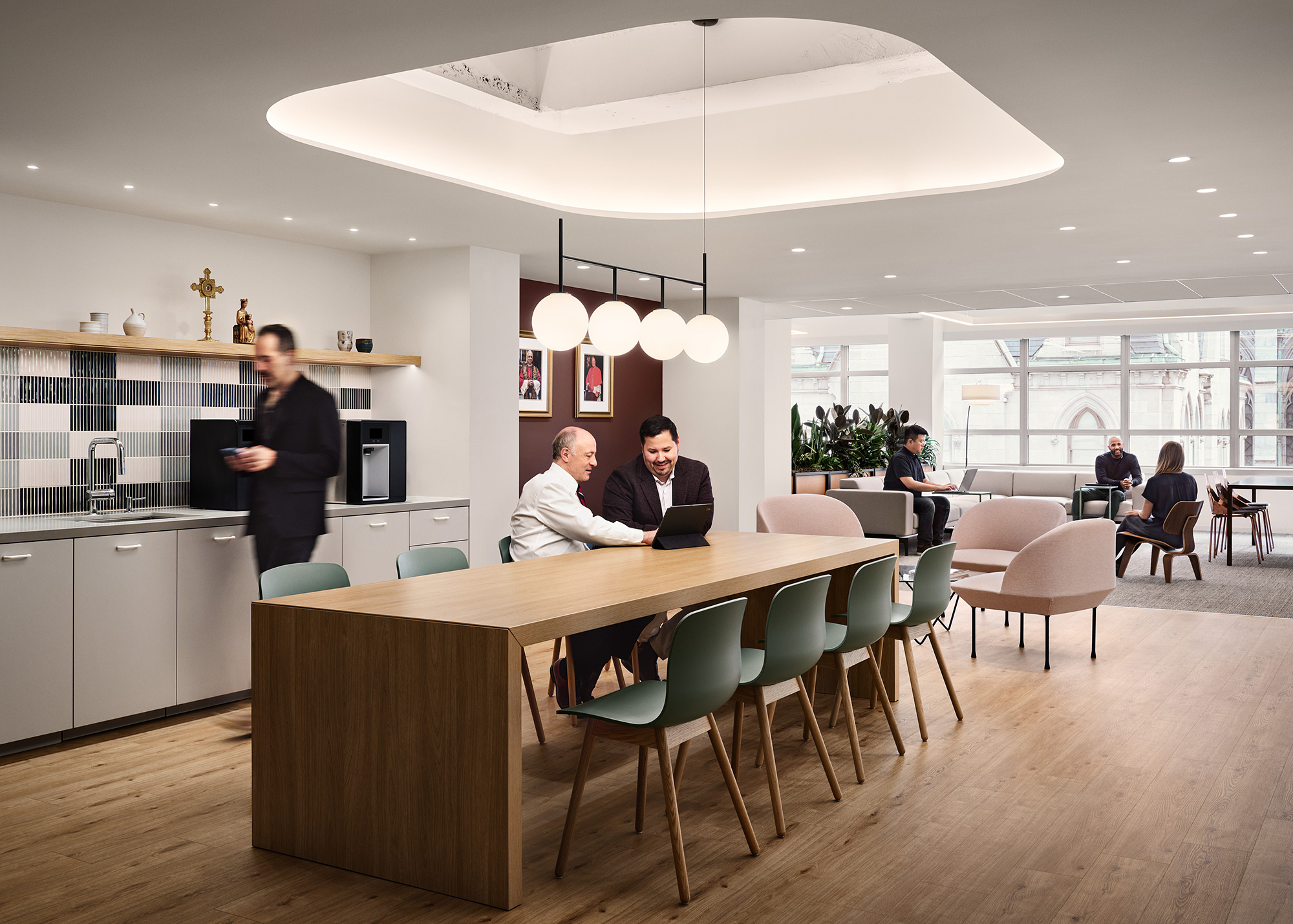 A group of people sitting at a table in a room with chairs.