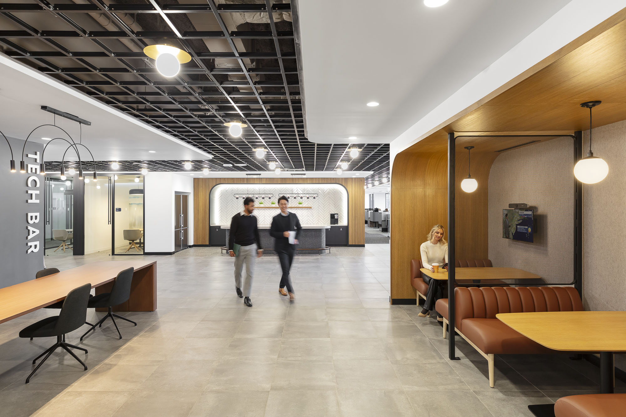 A few people walking in a building.