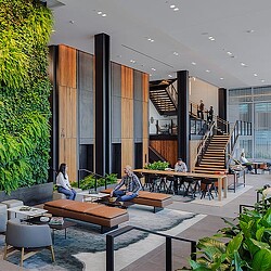 A modern looking house with a glass front and a few people sitting on the stairs.