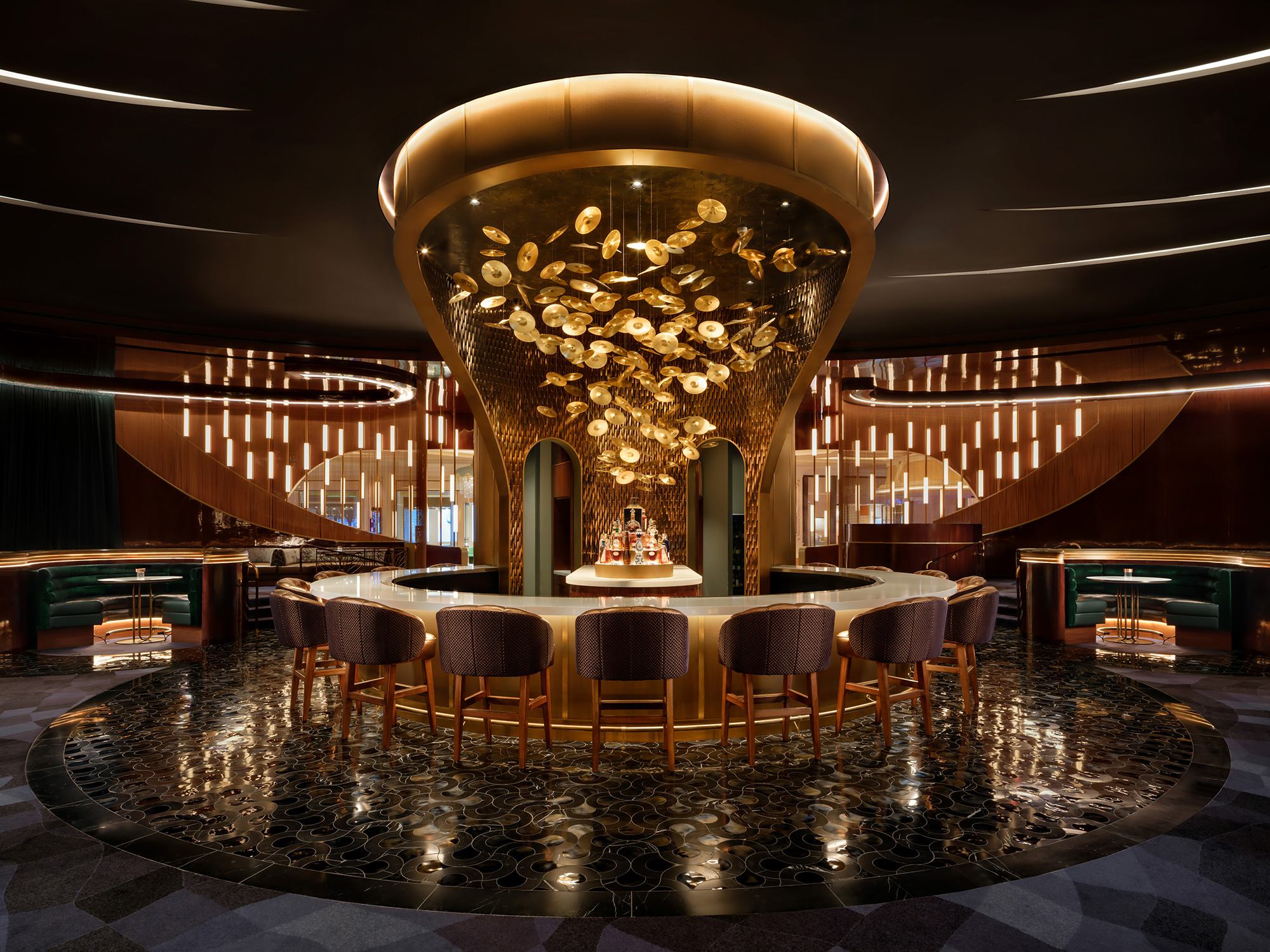 A large gold chandelier in a large room with chairs.