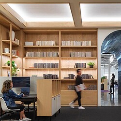 A person standing in front of a bookcase with books on it.