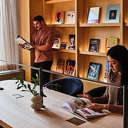 A woman reading a book to a man.