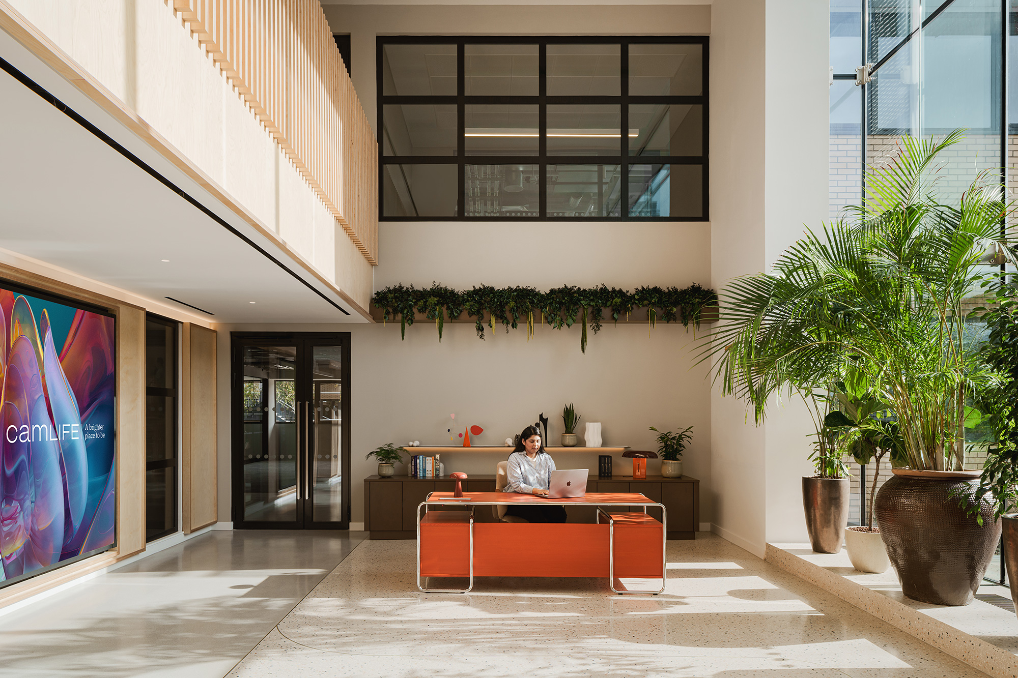 A person sitting at a desk in a building.