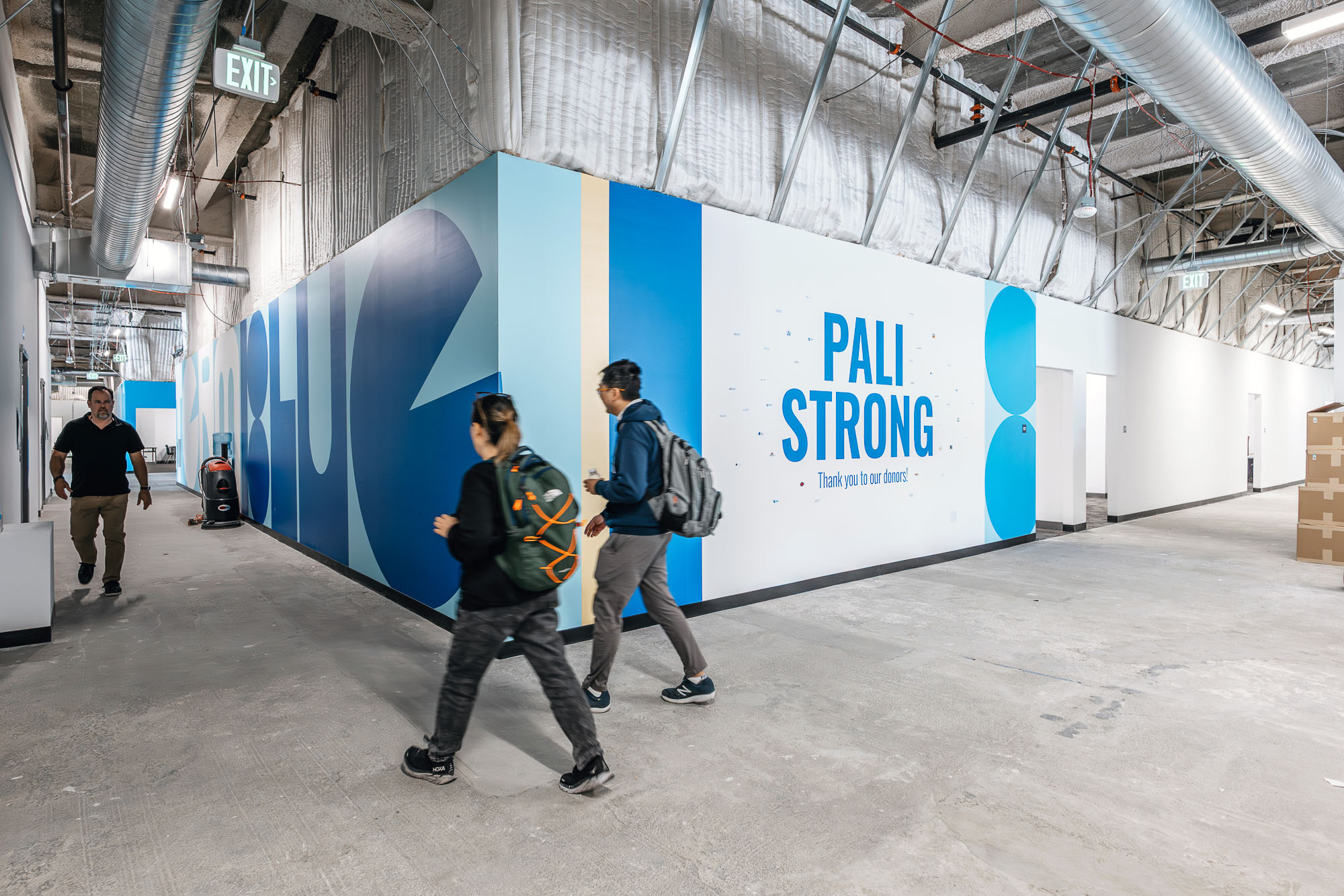 A group of people walking in a warehouse.