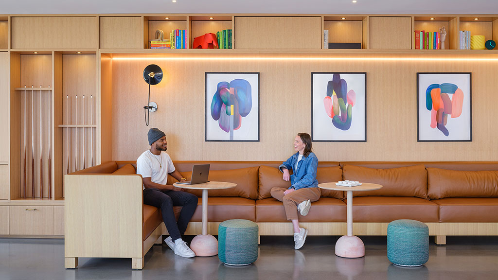 A man and a woman sitting on a couch with a laptop.