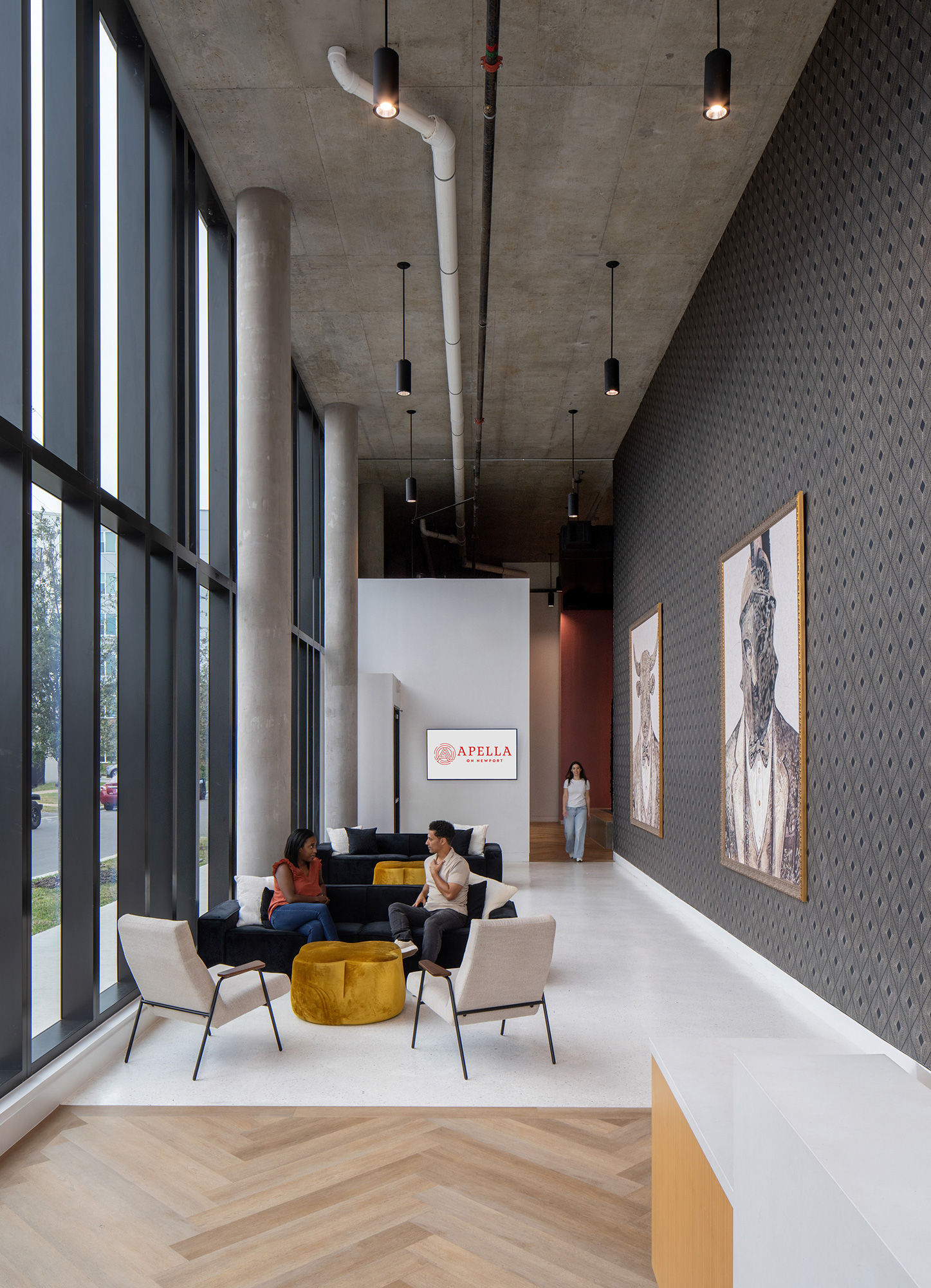 A group of people sitting in a room with art on the walls.