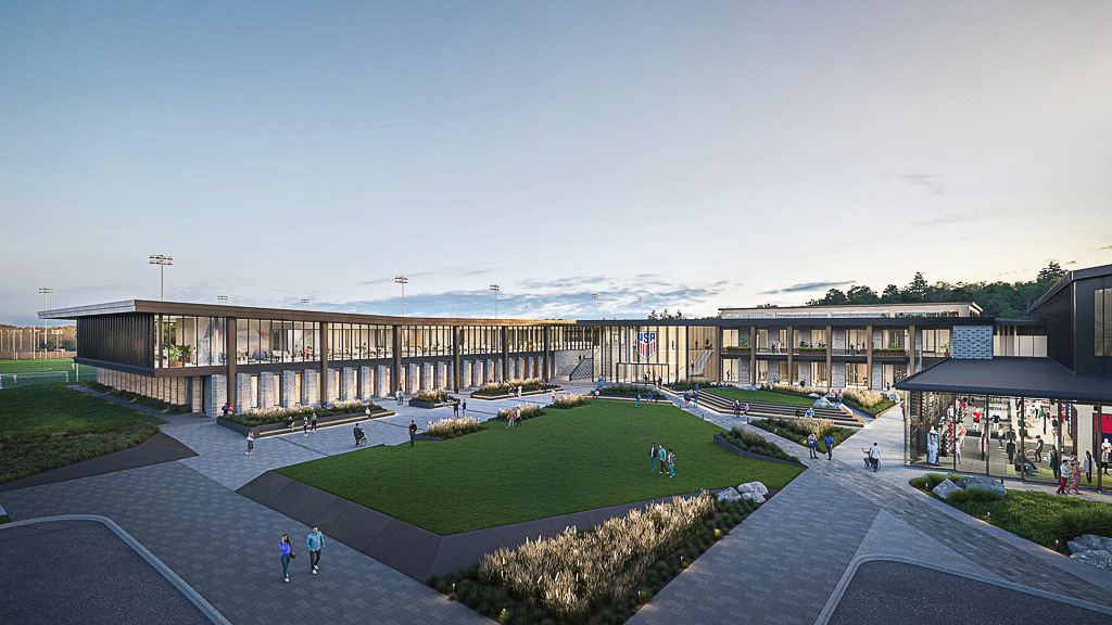 A large stadium with a green lawn.