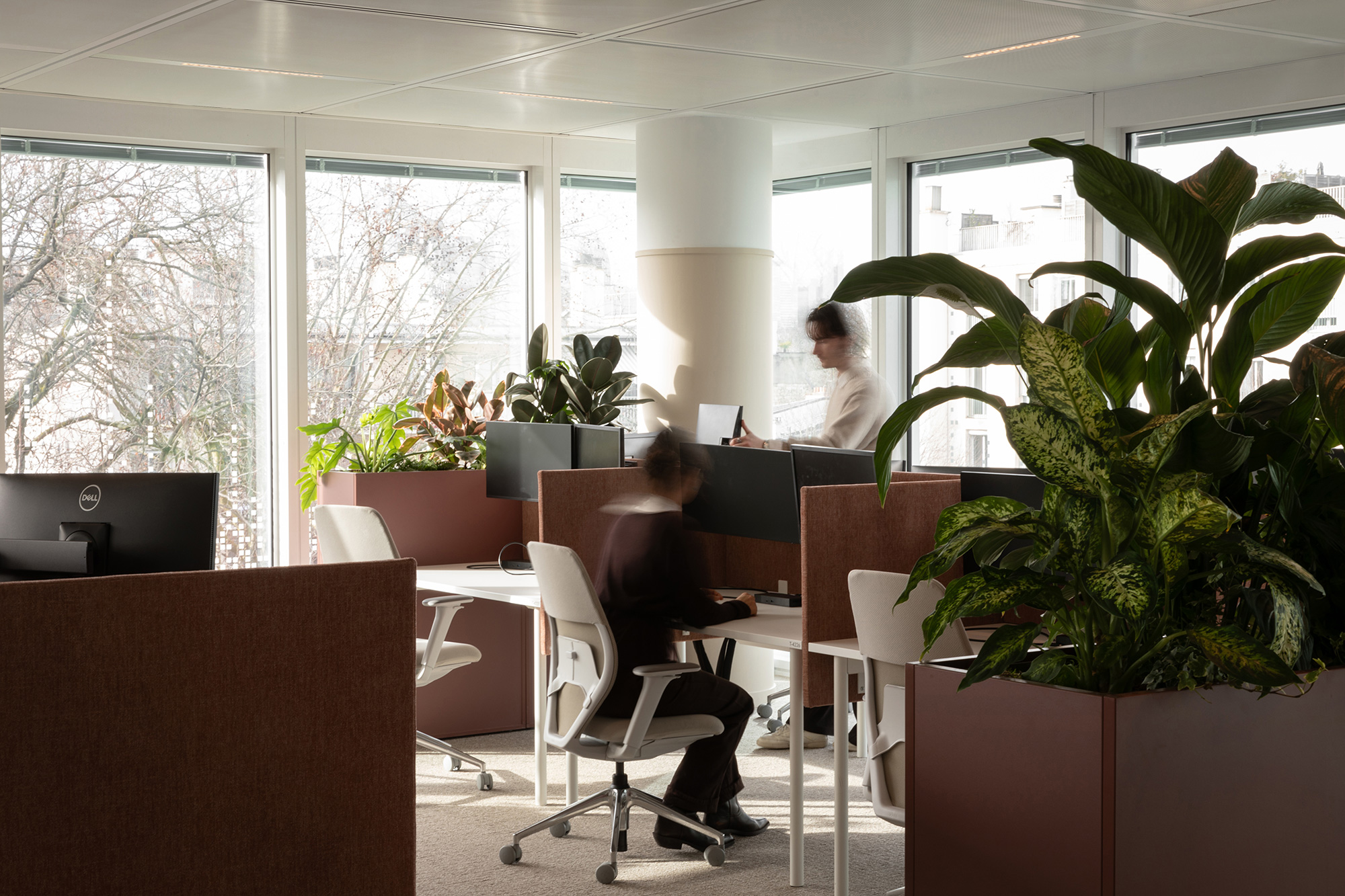 A man and woman sitting at a table in a room with windows.