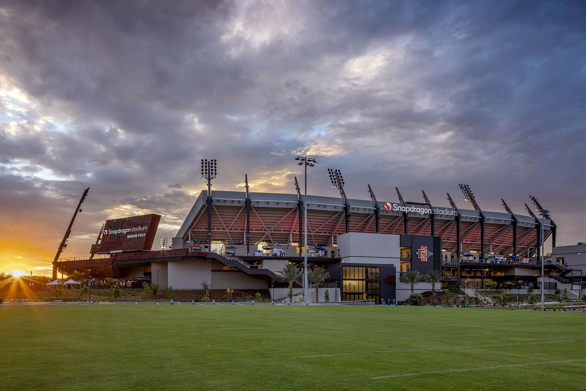 A stadium with a field in front of it.